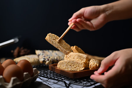 Hand holding Tempeh with bamboo chopsticks Vegan appetizers, traditional Indonesian soy product.の写真素材
