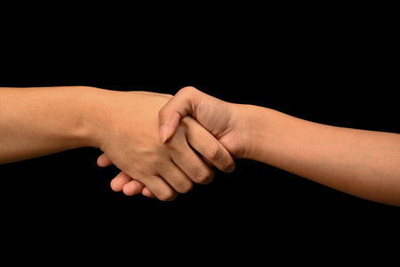 Man and woman shaking hands isolated on black background. Celebrating successful agreement, closing deal and greeting.の写真素材