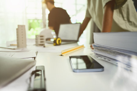 Architects workplace with digital tablet, safety helmet and blue prints on women table in modern...