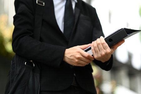 Businessman with briefcase walking on the city street, going to work.の写真素材
