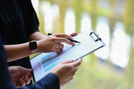 Cropped shot of young businesspeople analyzing statistics, financial results at meeting.の写真素材