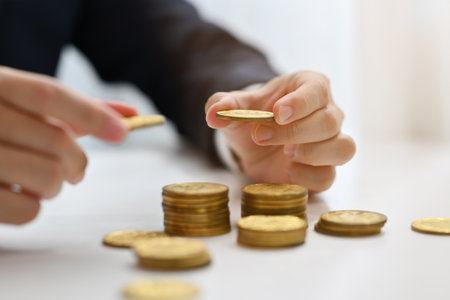Businessman putting coins to stack of coins. Saving money, investment and financial management...