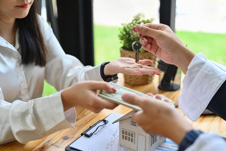 Male real estate agent receiving money from a client after signing contract in office. Real estate, mortgage, loan and insurance.の写真素材
