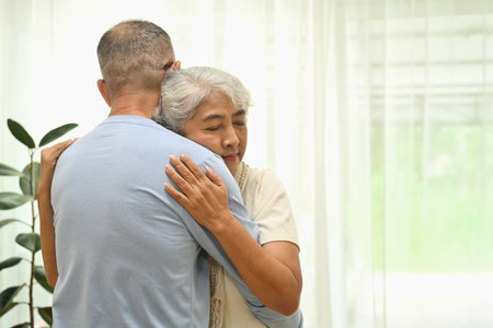 Happy senior couple hugging, bonding, enjoying wellbeing and spending free time together at home.の写真素材