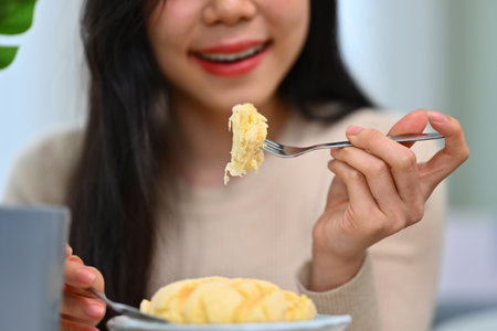 Happy young asian woman eating homemade low fat cake in cafe. People, food and lifestyle concept.の写真素材