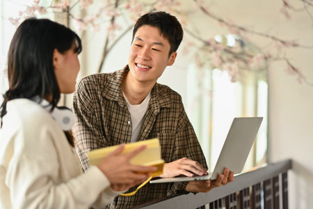 University students using laptop for researching online, collaborating on a project in campus.の写真素材