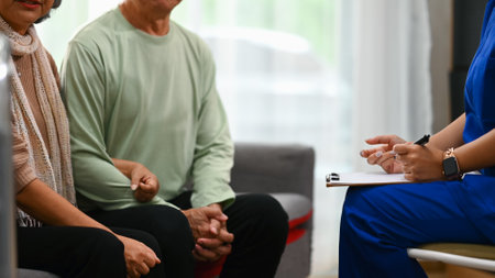 Female doctor explaining therapy details to mature man during home visit. Elderly healthcare concept.の写真素材