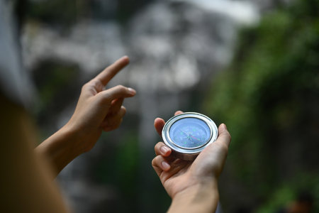 Unrecognizable male hiker using compass for directions while exploring nature in the forest.の写真素材