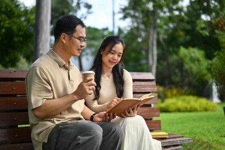 Middle age asian man and young adult daughter enjoying spending weekend time together at the park.の写真素材