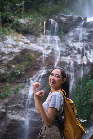 Portrait of female tourist making winner yes gesture celebrating success at beautiful tropical...