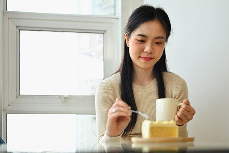 Pretty young woman drinking coffee and eating diet at coffee shop during lunch break.