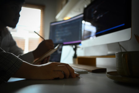 Professional software developers working on a new project, writing program code on computer in...