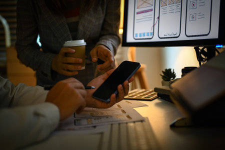 Developers team working on new website wireframe, planning application development in dark room.