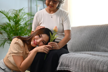 Smiling adult daughter greeting happy mature mother and giving tulip flowers. Happy Mothers day...