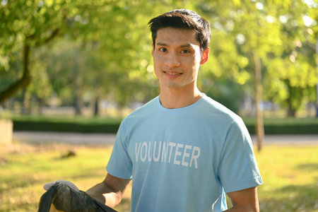 Portrait of male volunteer cleaning up and separating garbage at outdoor. World Environment Day concept.の写真素材