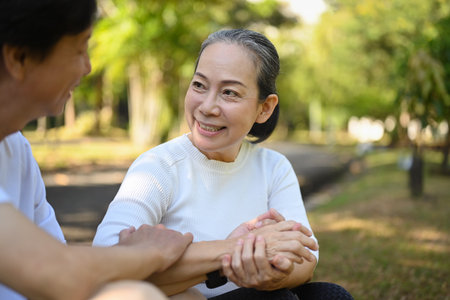 Caring middle age woman holding hand husband and looking with love. Retirement couple love and care conceptの写真素材