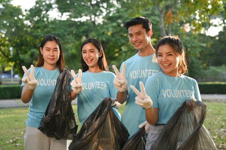 Group of young volunteer collecting trash in the park. Environmental protection and charity concept.の写真素材