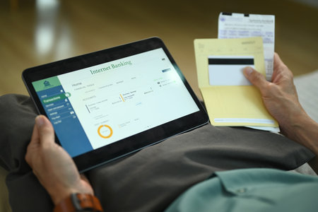 Closeup unrecognizable man using digital tablet and credit card for online payments