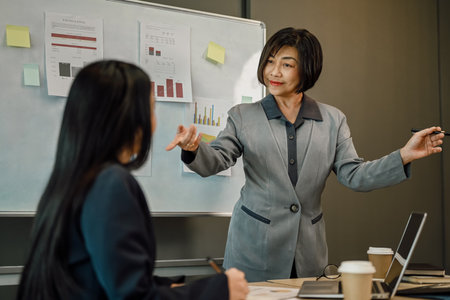 Smiling middle age female coach asking question during presentationの写真素材