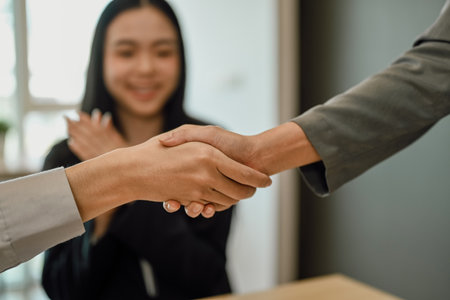 Successful businesspeople shaking hands closing deal or making agreement after successful negotiations.の写真素材