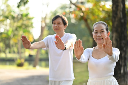 Beautiful active middle age couple doing Qi Gong or Tai Chi exercise for relaxation and health.の写真素材