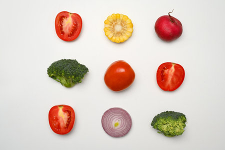 Sliced different fresh vegetables on white background. Healthy food, vegetarian and nutrition conceptの写真素材
