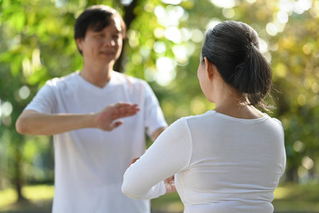 Asian senior couple doing Qigong exercises in the park. Healthy lifestyle conceptの写真素材