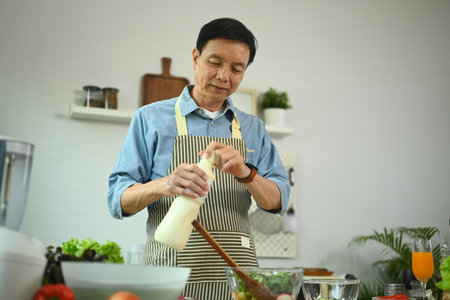 Portrait of senior man cooking healthy food at kitchen. Healthy lifestyle concept.の写真素材