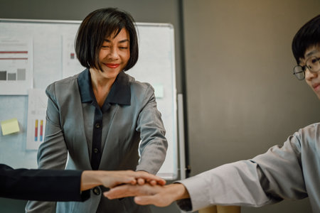 Businesspeople stacking hands together at meeting table. Concept of corporate unity and solidarity.の写真素材