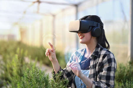 Farmer wearing VR headset for controlling process in greenhouse cultivation. Modern and smart...