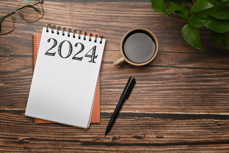 Notepad with 2024 text to apply New Year 2024 resolutions. Goals, resolutions and plan concept.の写真素材