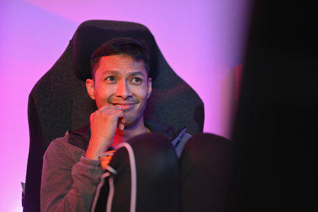 Handsome young man eating popcorn and watching a movie on computer at night