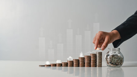Hand stacking coins with heights up arrow icons. Income Management and saving money concepts.