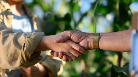 Cropped shot of two unrecognizable farmers shaking hands at the cornfield. Agreement and contract in agriculture.の写真素材