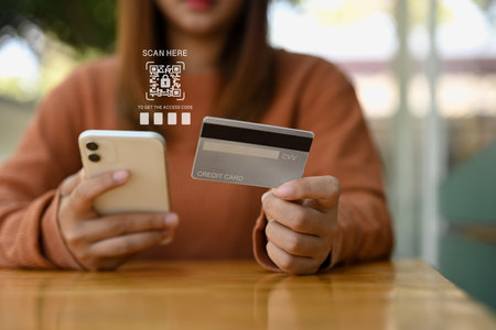 Woman scanning verification QR code login to bank account on mobile phone. Cybersecurity concept.の写真素材