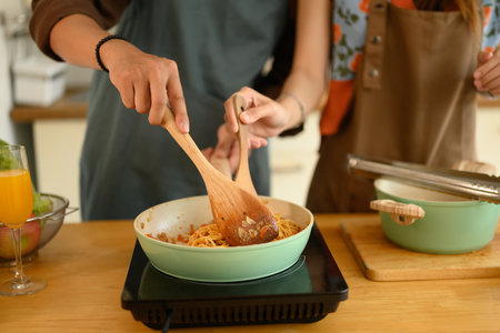 Cropped shot of young couple making delicious bolognese sauce for dinner in kitchen.の写真素材