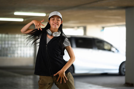 Talented young woman dancing Hip hop dance in parking garage. Hobby and active lifestyle concept.