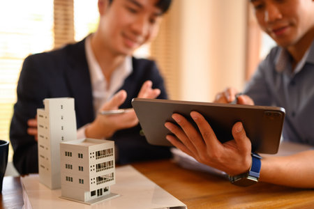 Architects team working with architectural model model of residential at meeting. Construction,...