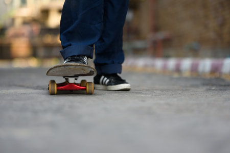 Legs of hipster man practicing skateboarding on city street. Recreational activity concept.の写真素材