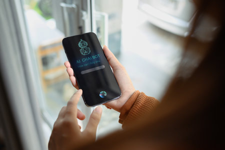 Over shoulder view of woman using AI Chat bot in mobile application and giving voice commands.