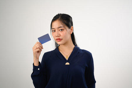 Portrait of beautiful young woman holding credit bank card isolated on white background.の写真素材