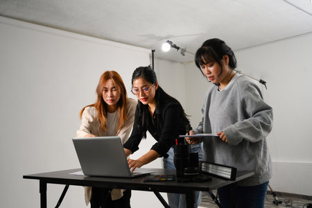 Young creative people using laptop working together in a professional studio.の写真素材