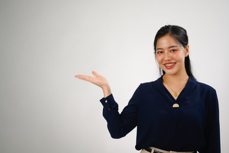Beautiful businesswoman showing aside presenting advertising offer on white background.の写真素材