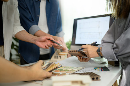Group of designers of interior choosing material samples, working together at creative office.の写真素材