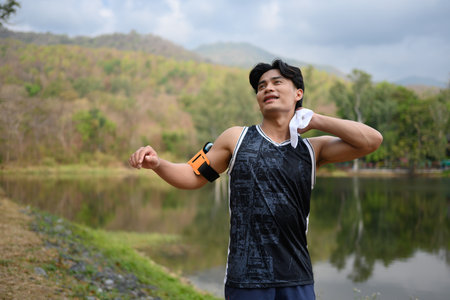 Portrait of male runner wiping sweat and relaxing after sport training outdoor.の写真素材