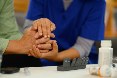 Caring nurse holding hands comforting upset senior patient. Elderly healthcare concept.の写真素材