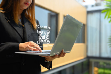 Qr code over businesswoman hand using laptop for paying financial bill. Security concept.