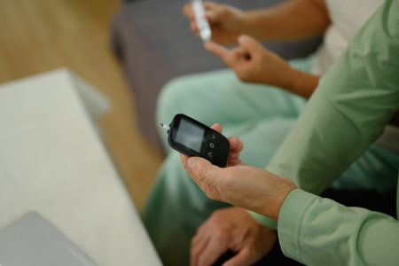 Mature man using glucose meter for checking blood sugar level. Diabetes and health care concept.の写真素材