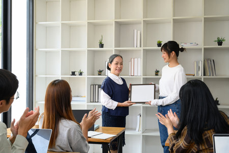 Happy student woman accepting certificate from her professor. Education concept.の写真素材
