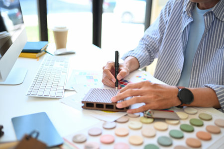 Cropped shot of senior male decorator working with material sample board at his office.の写真素材